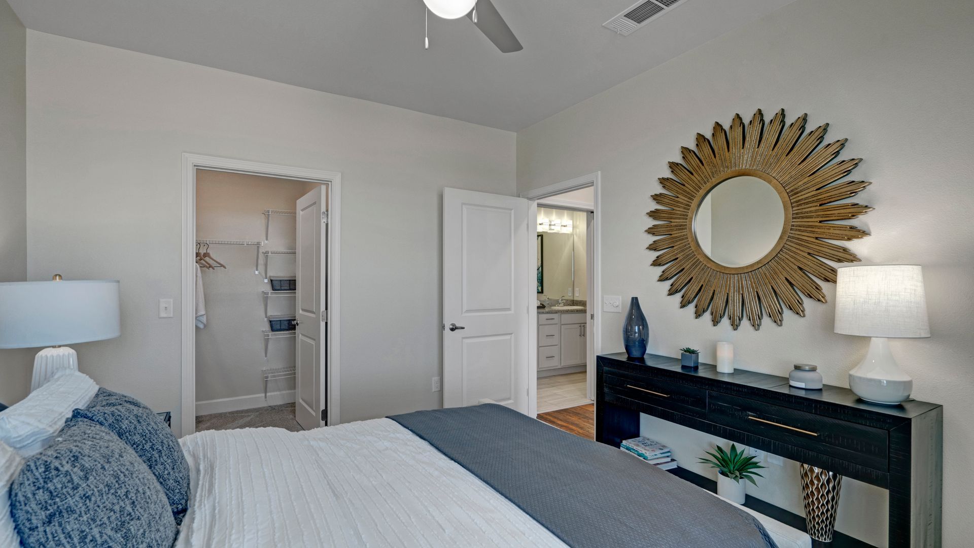 A bedroom with a large bed and a mirror on the wall.