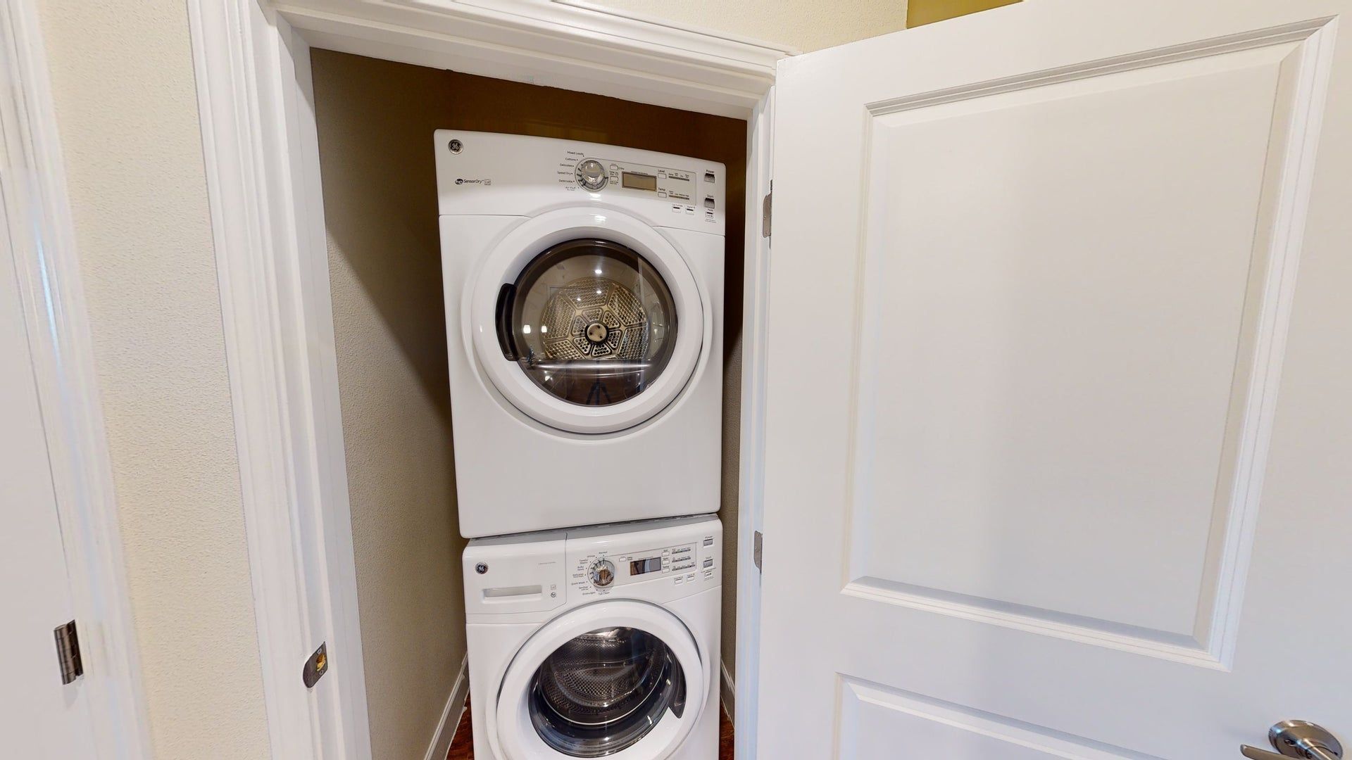 A washer and dryer are stacked on top of each other in a laundry room.