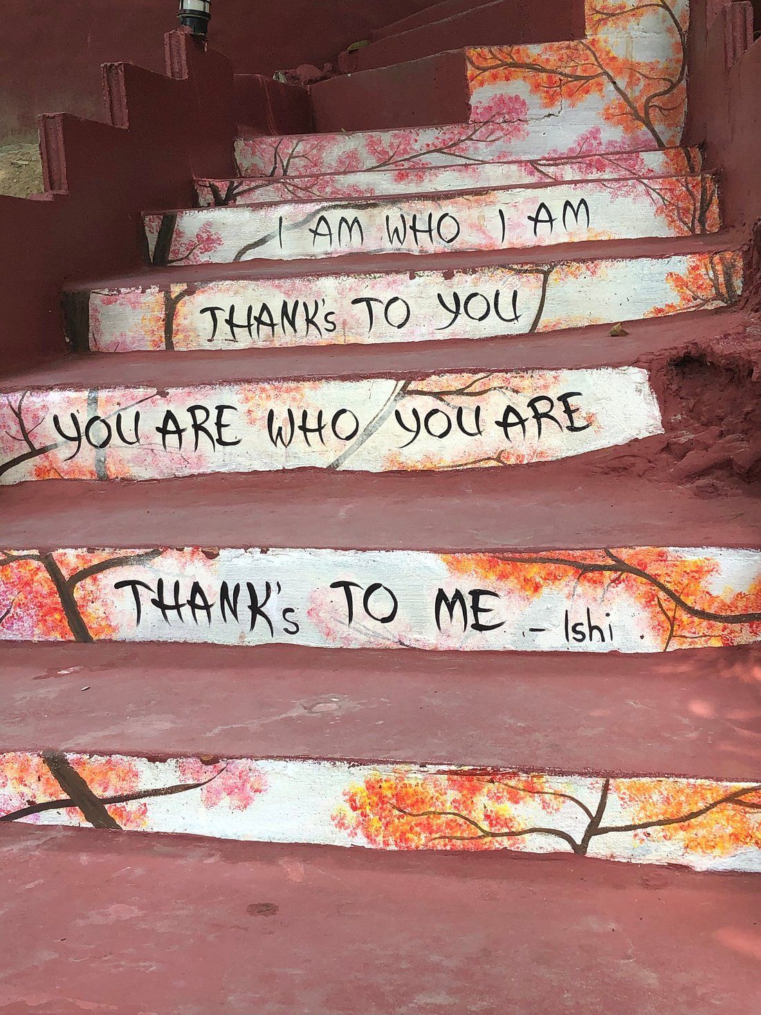 Painted staircase with floral design and motivational quotes 
