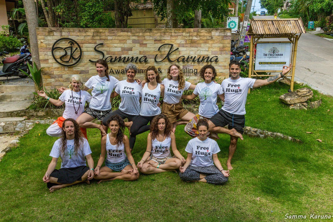 Group of people doing yoga poses in front of 