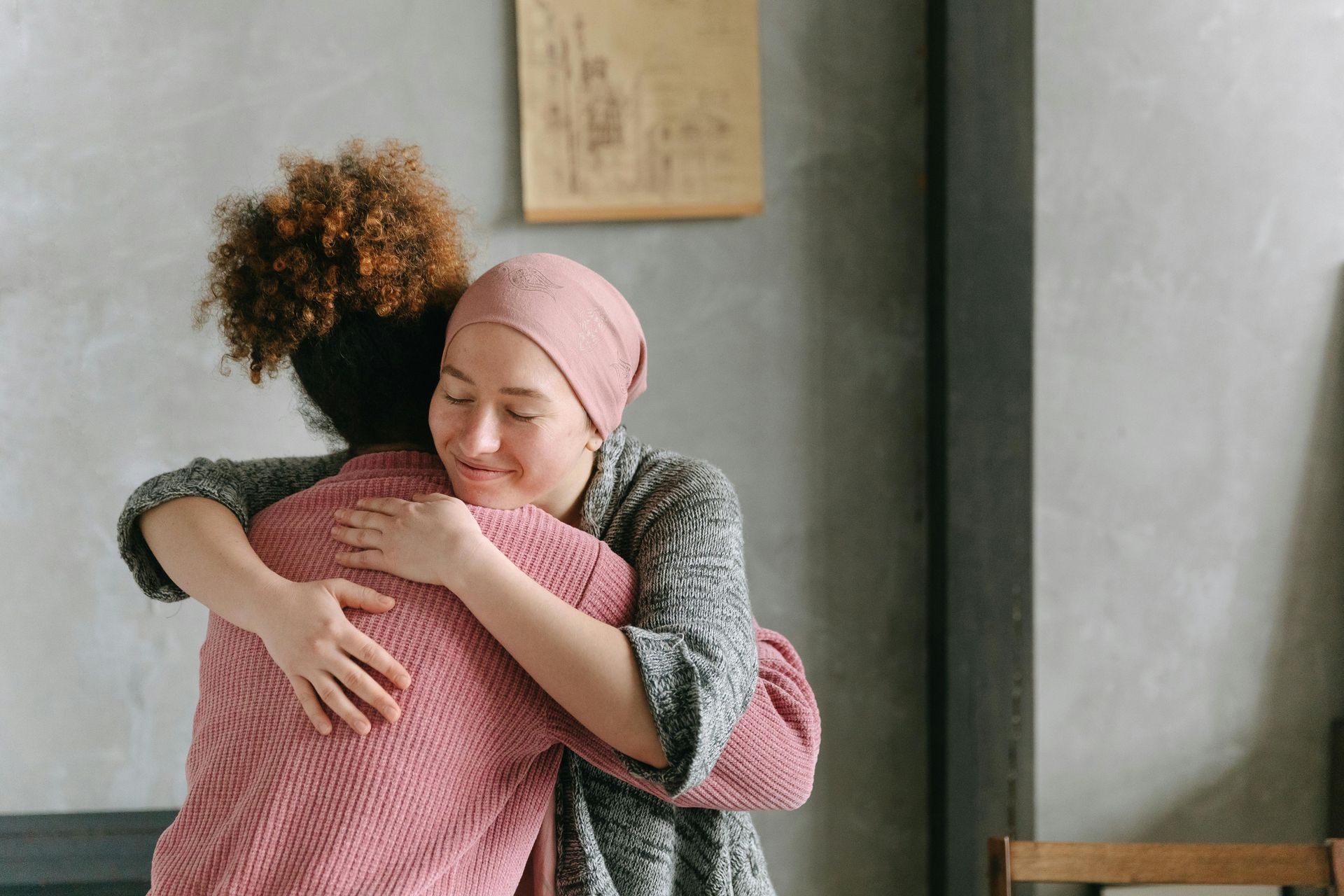 Two women are hugging each other in a living room.