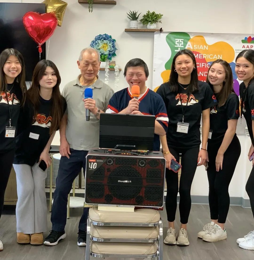 A group of people posing for a picture in front of a speaker