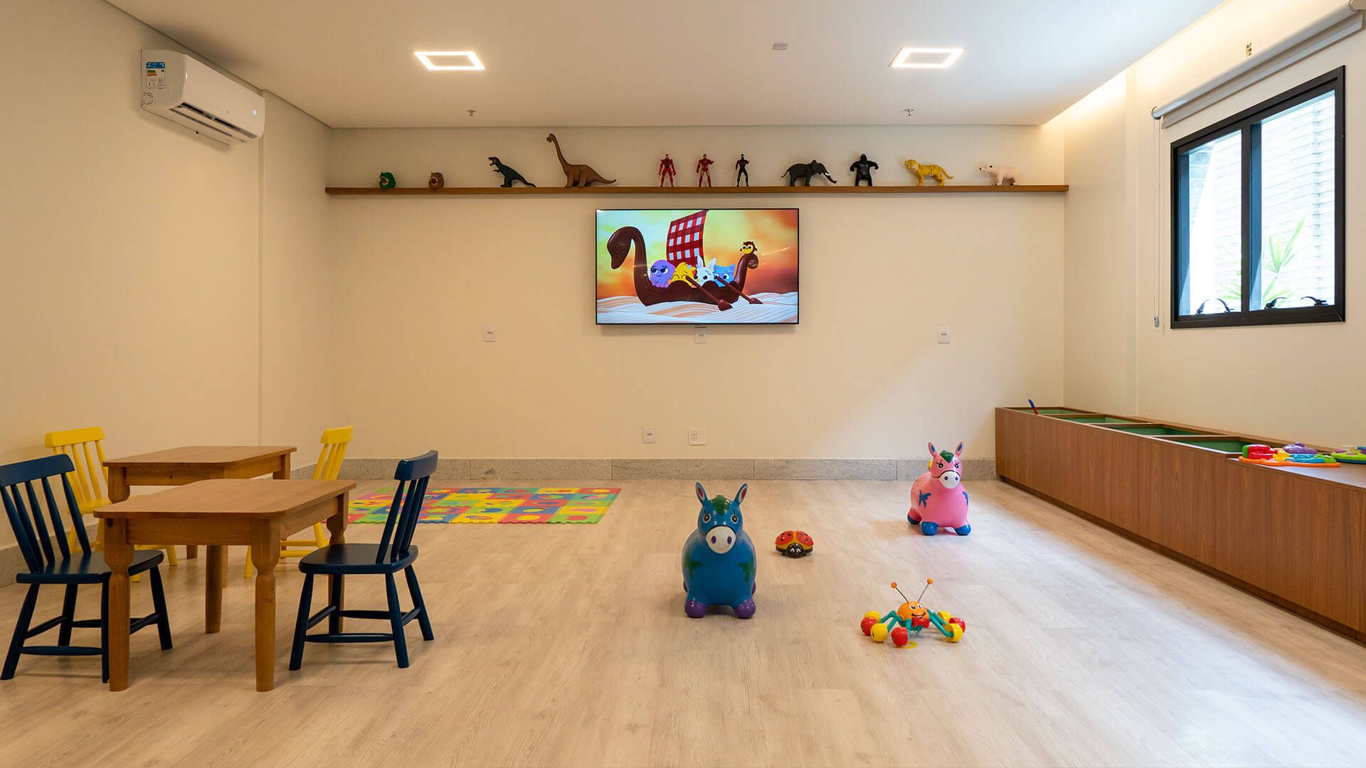 Sala de recreação infantil com televisão e outros brinquedos infantis