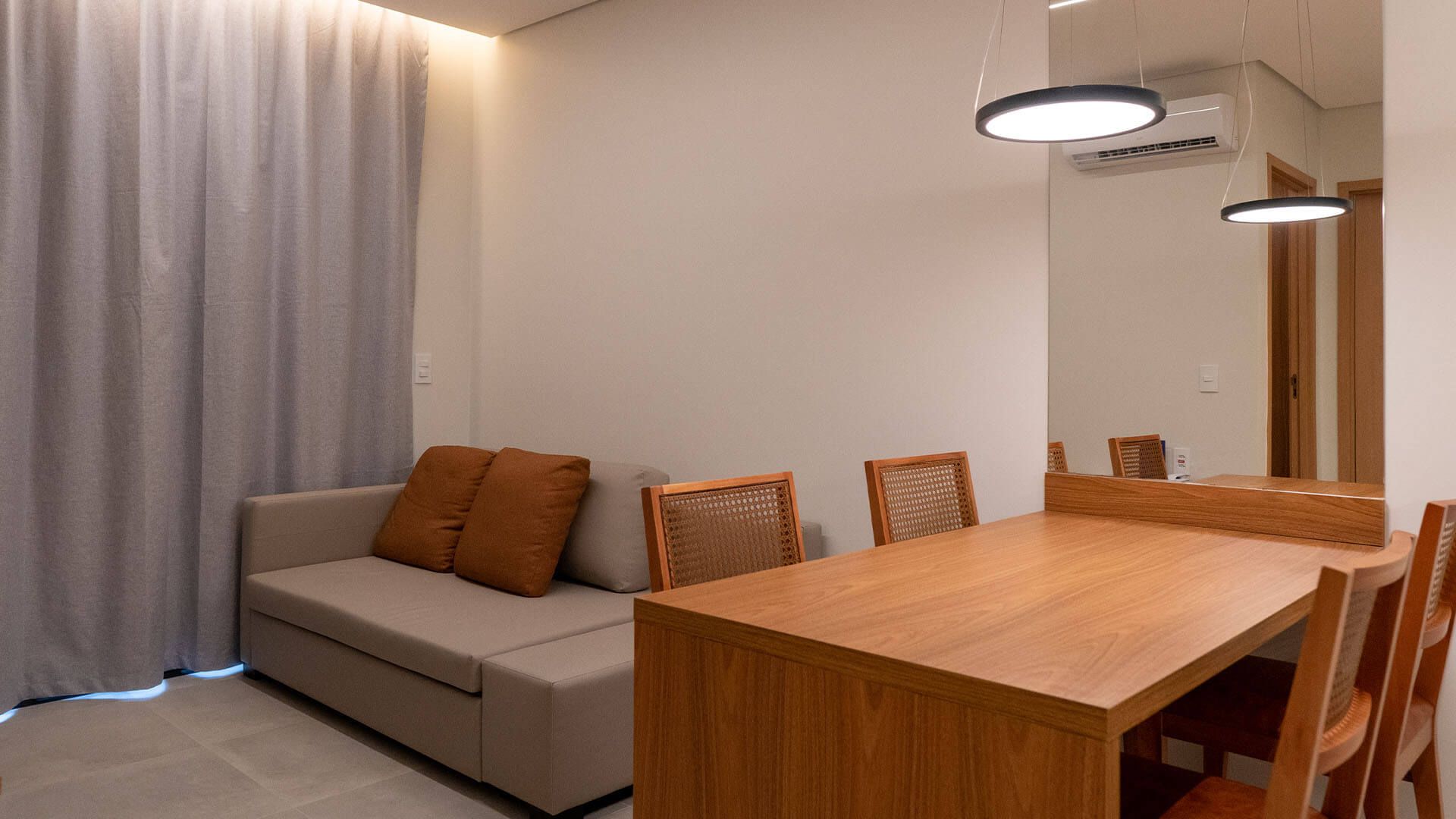 Uma sala de estar com sofá, mesa e cadeiras.