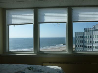 A bedroom with a view of the ocean and buildings