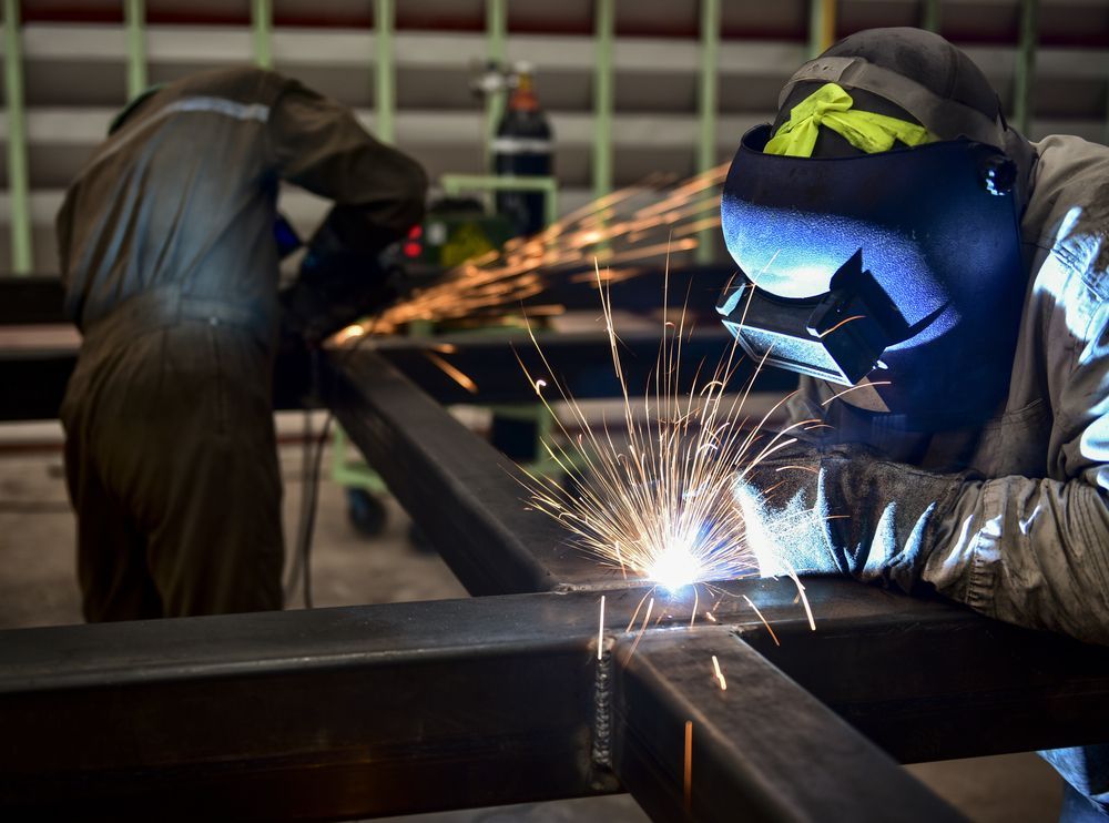 Welder in Protective Mask Sparks While Joining Metal Beams in a Workshop — GC Custom Fabrication in Coomera, QLD