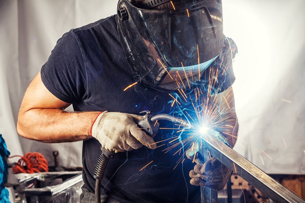Welder Wearing a Mask and Gloves, Using a Welding Torch, Sparks Flying — GC Custom Fabrication in Molendinar, QLD