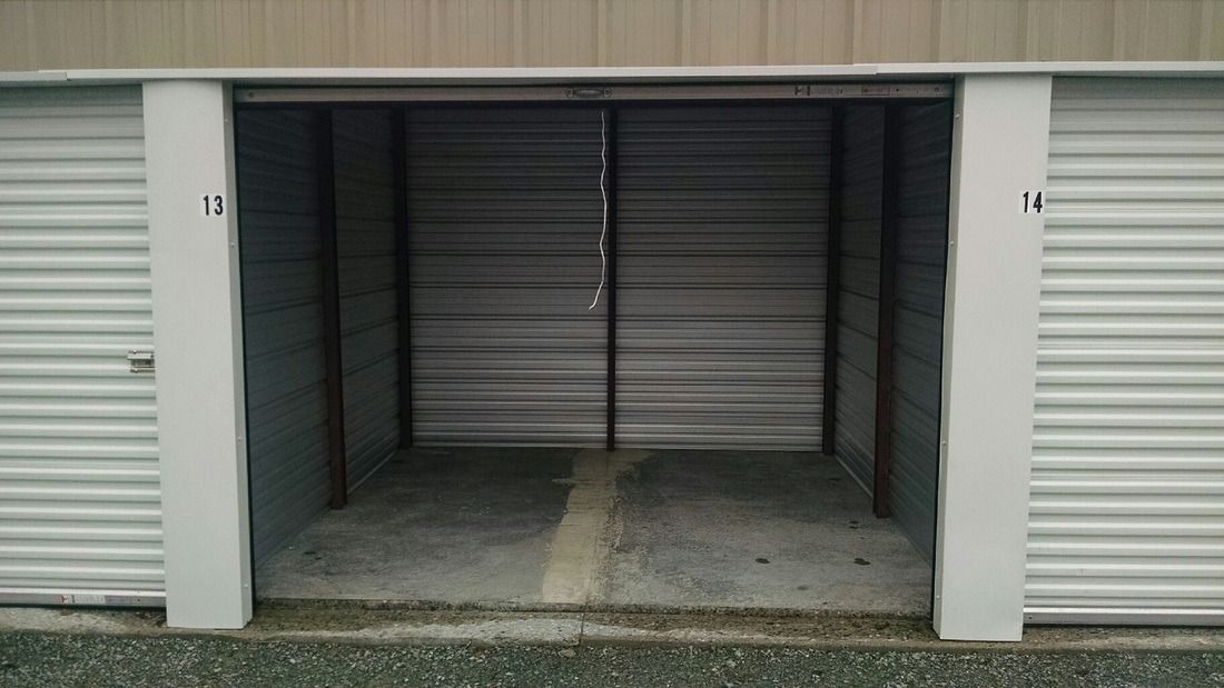 Empty storage unit with the door open, numbers 13 and 14 on either side.