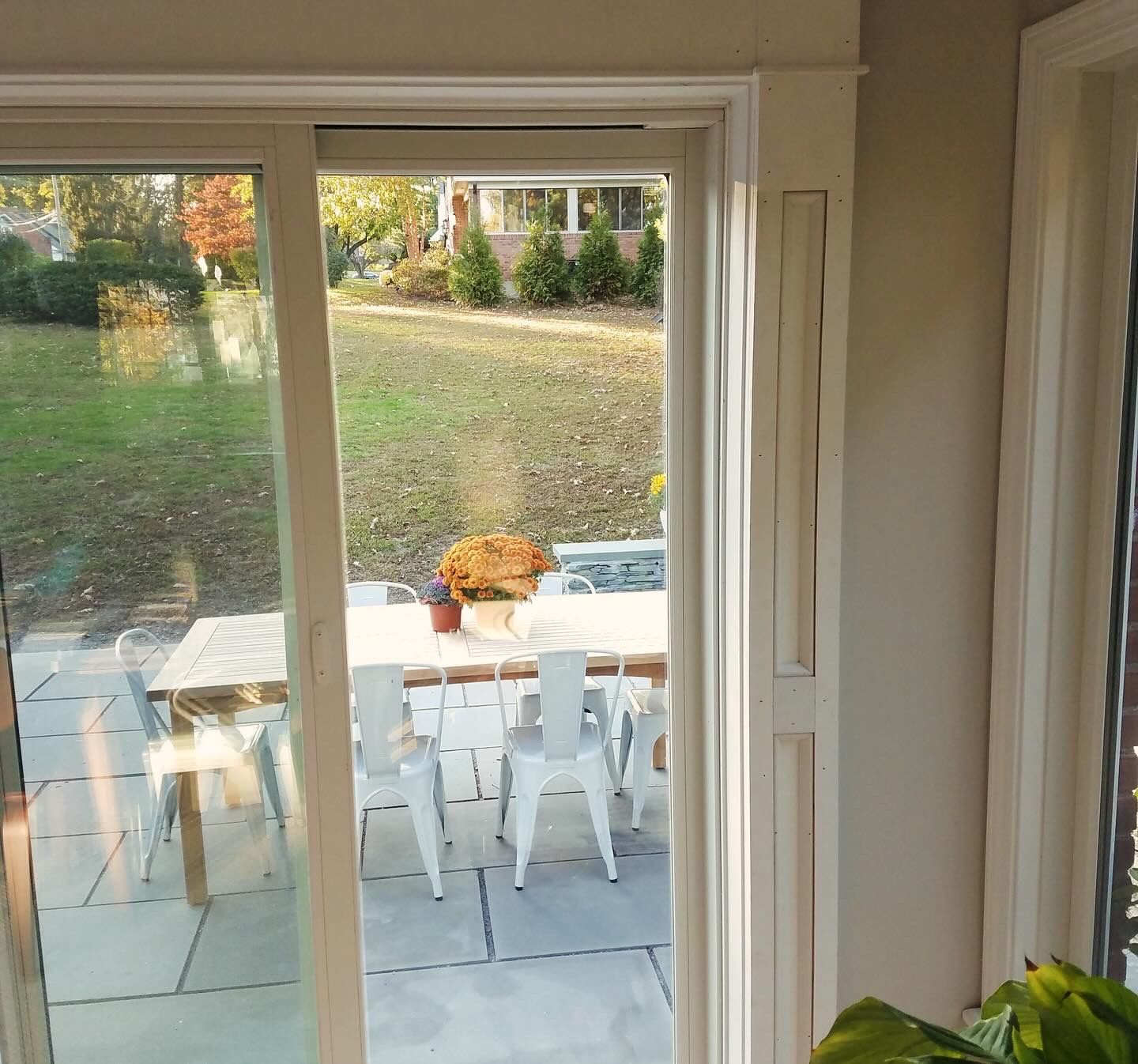 A sliding glass door leading to a patio with a table and chairs