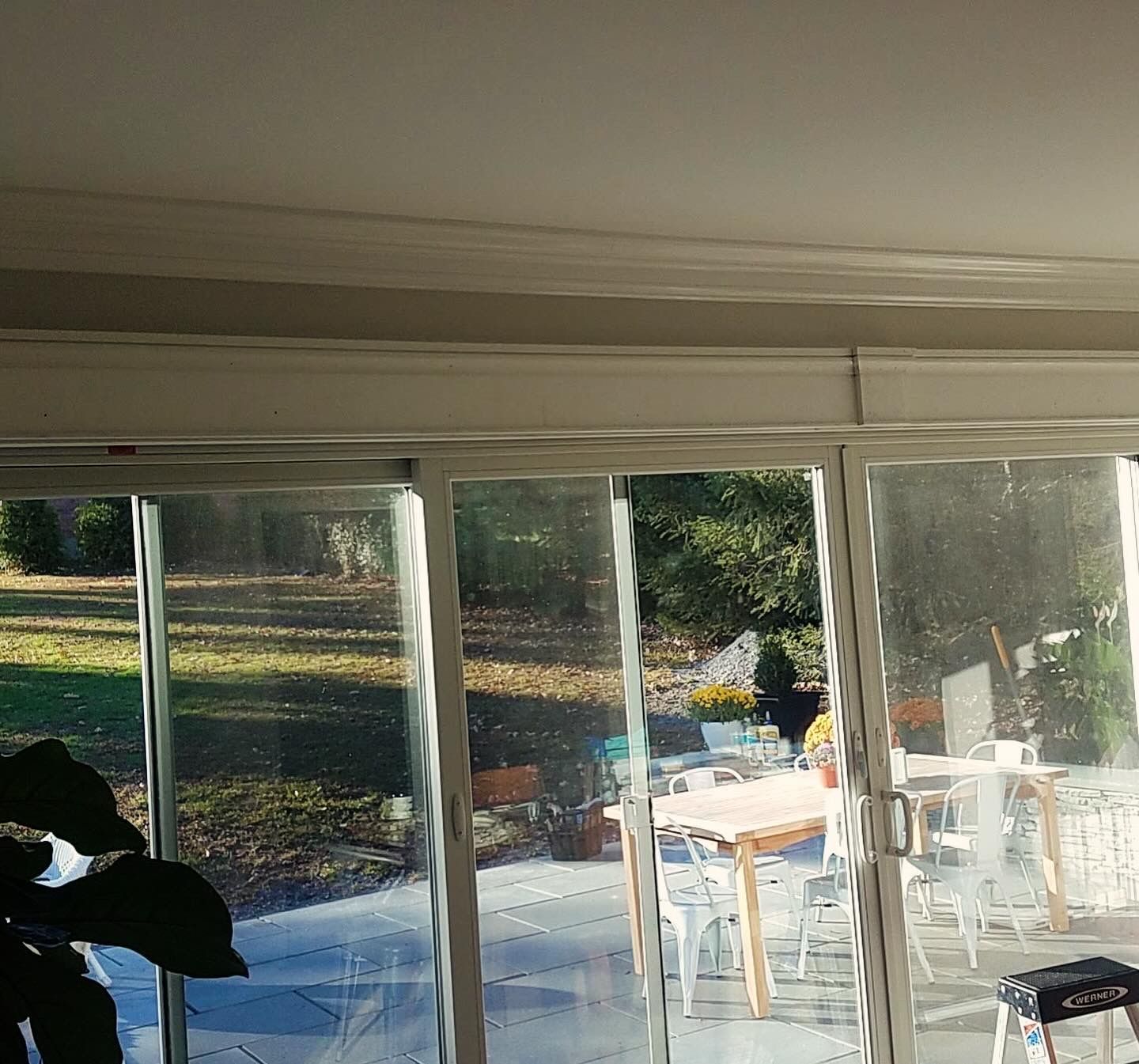 A sliding glass door leading to a patio with a table and chairs