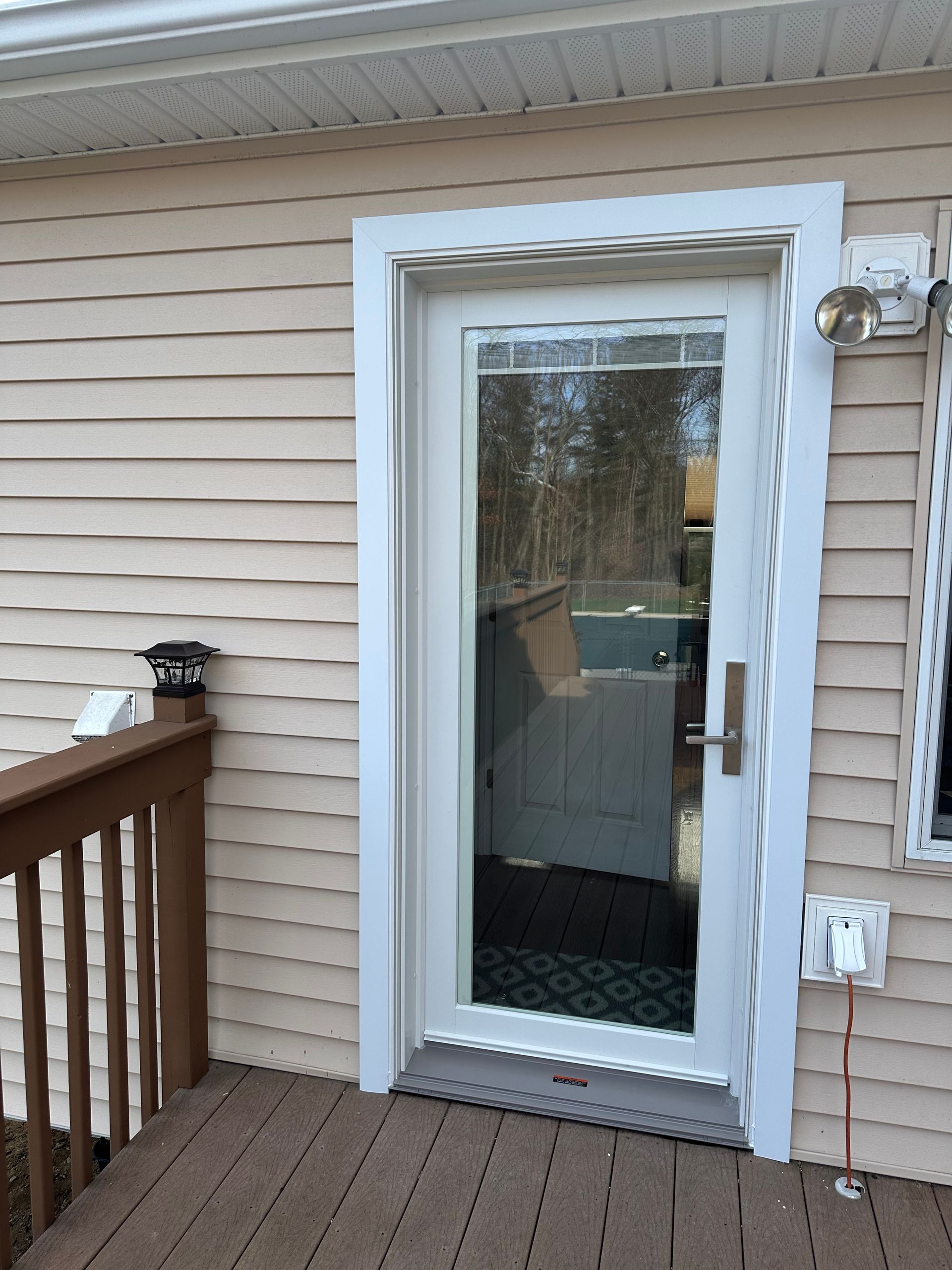 A house with a glass door and a wooden deck