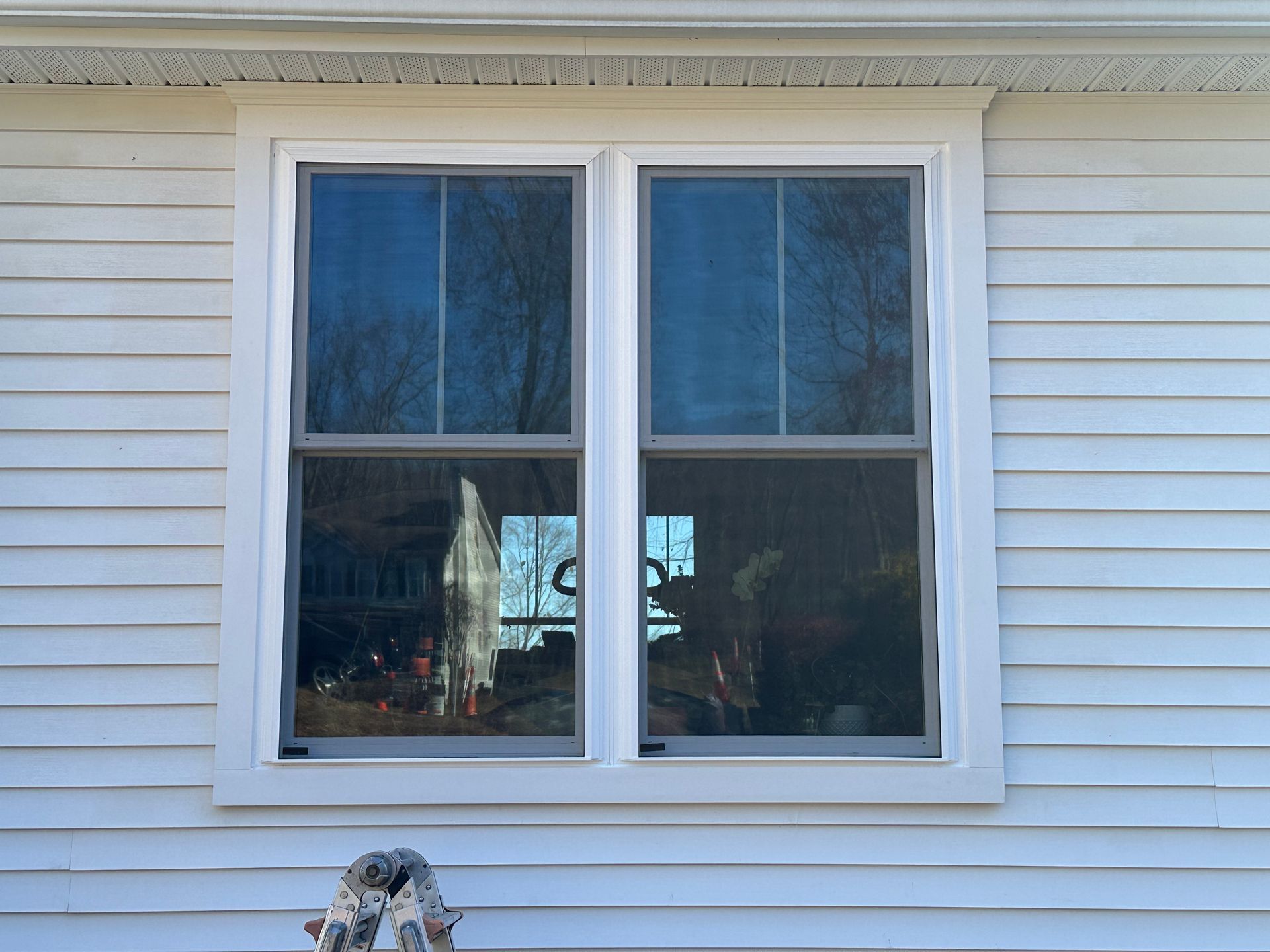 A white house with two windows on the side of it