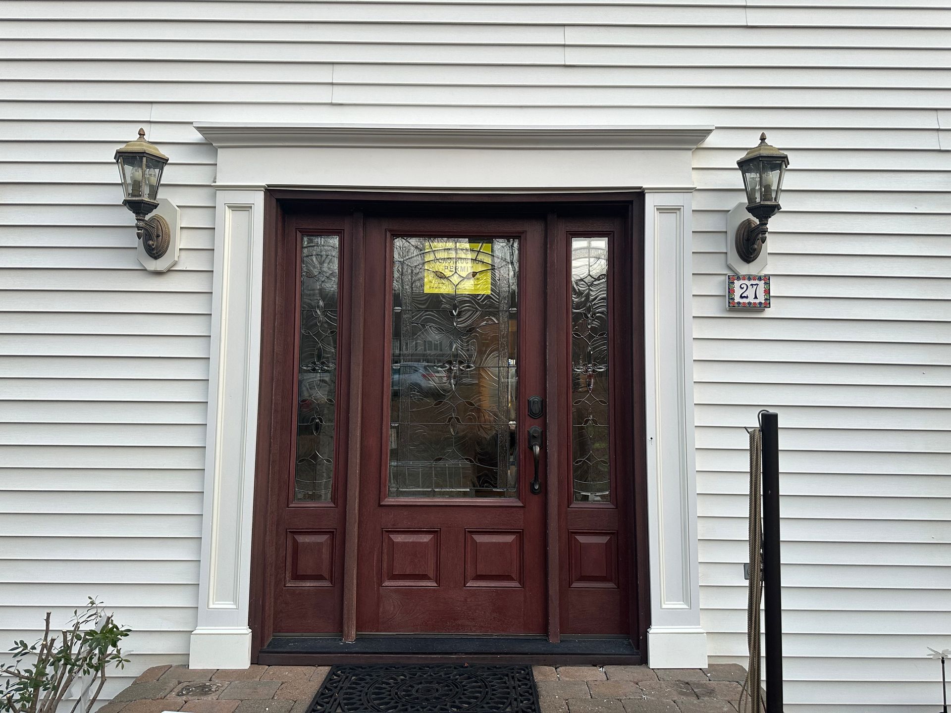 The front door of a white house with a brown door