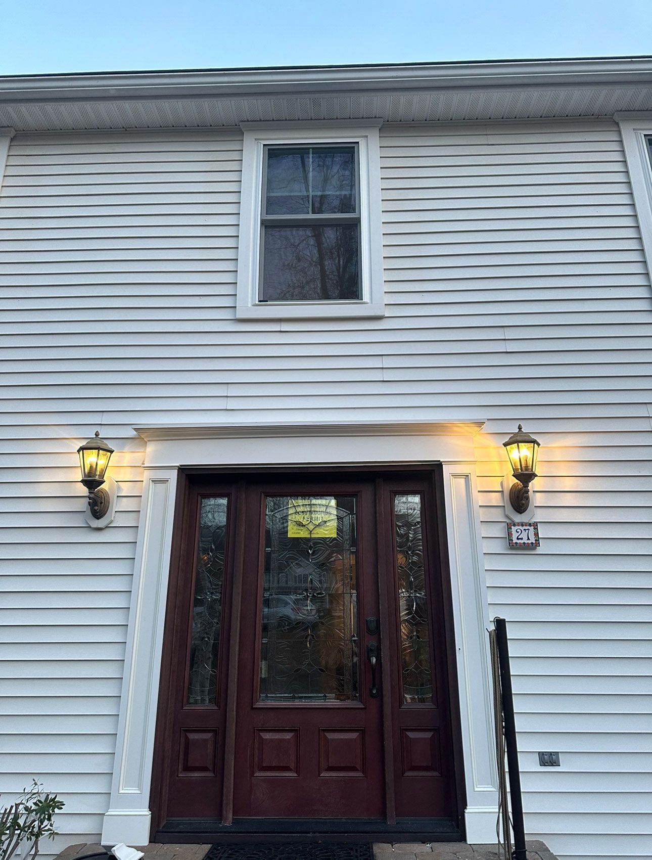 The front of a white house with a brown door
