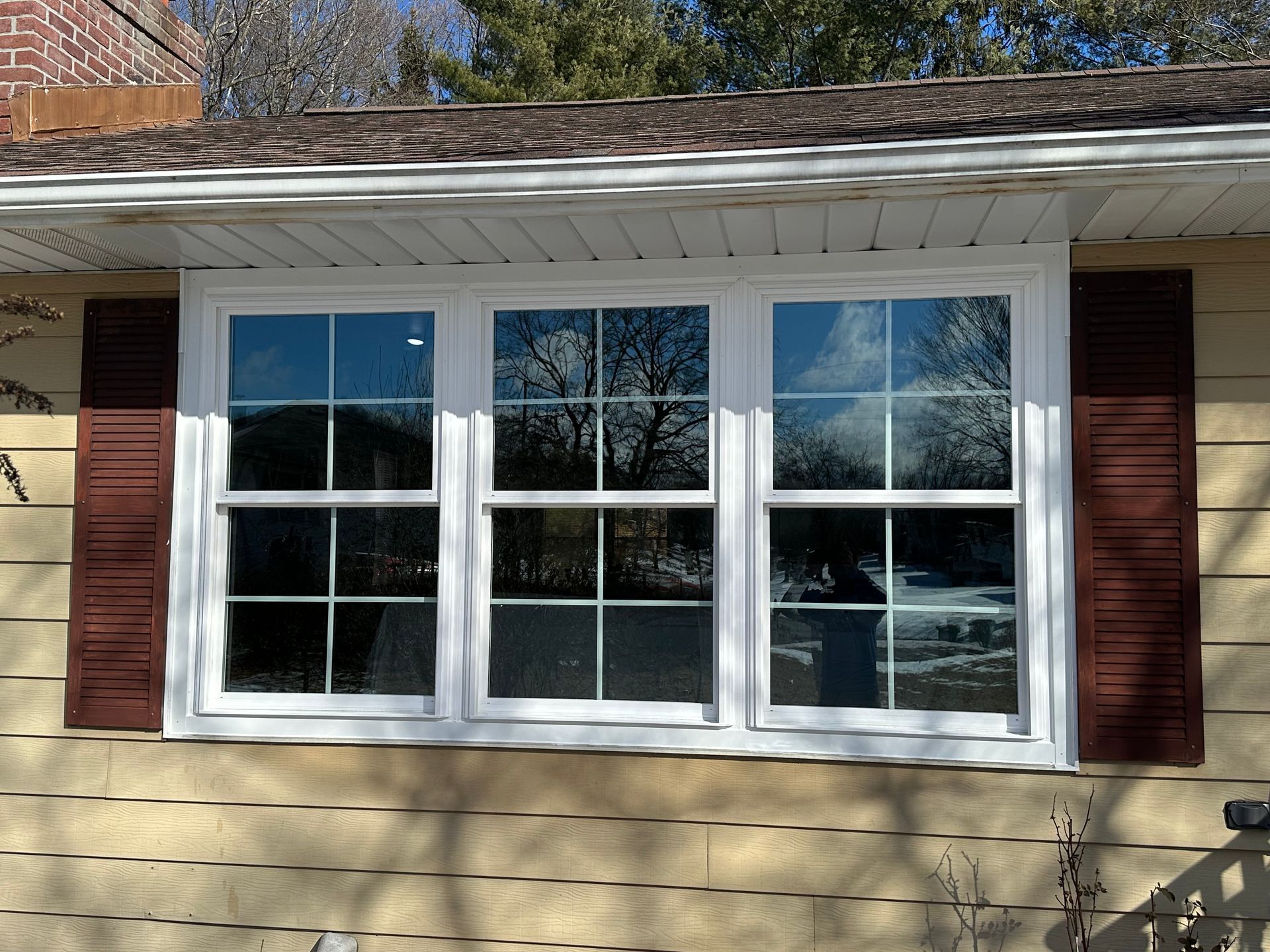 A house with a large window and brown shutters