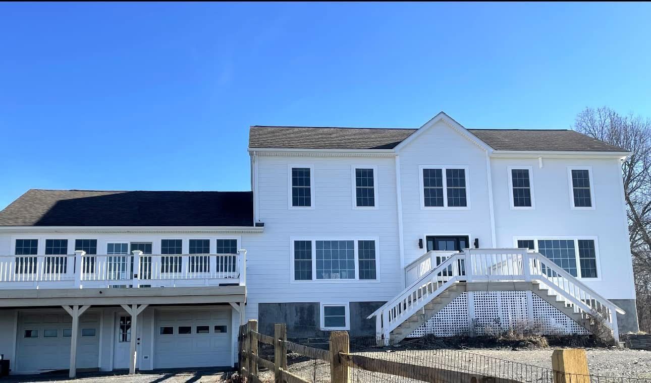 A large white house with a large deck and stairs
