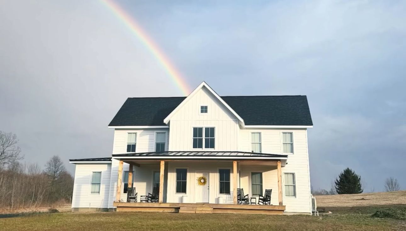 A white house with a rainbow in the sky