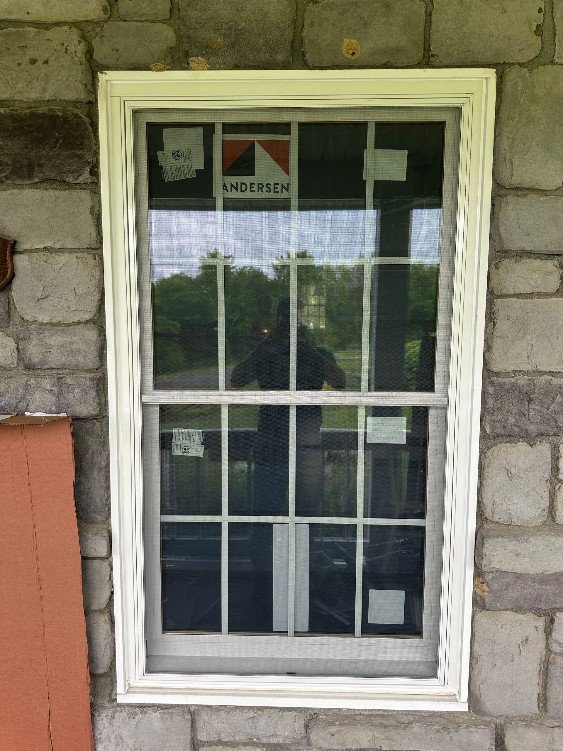 A window on a brick wall with the word anderson on it