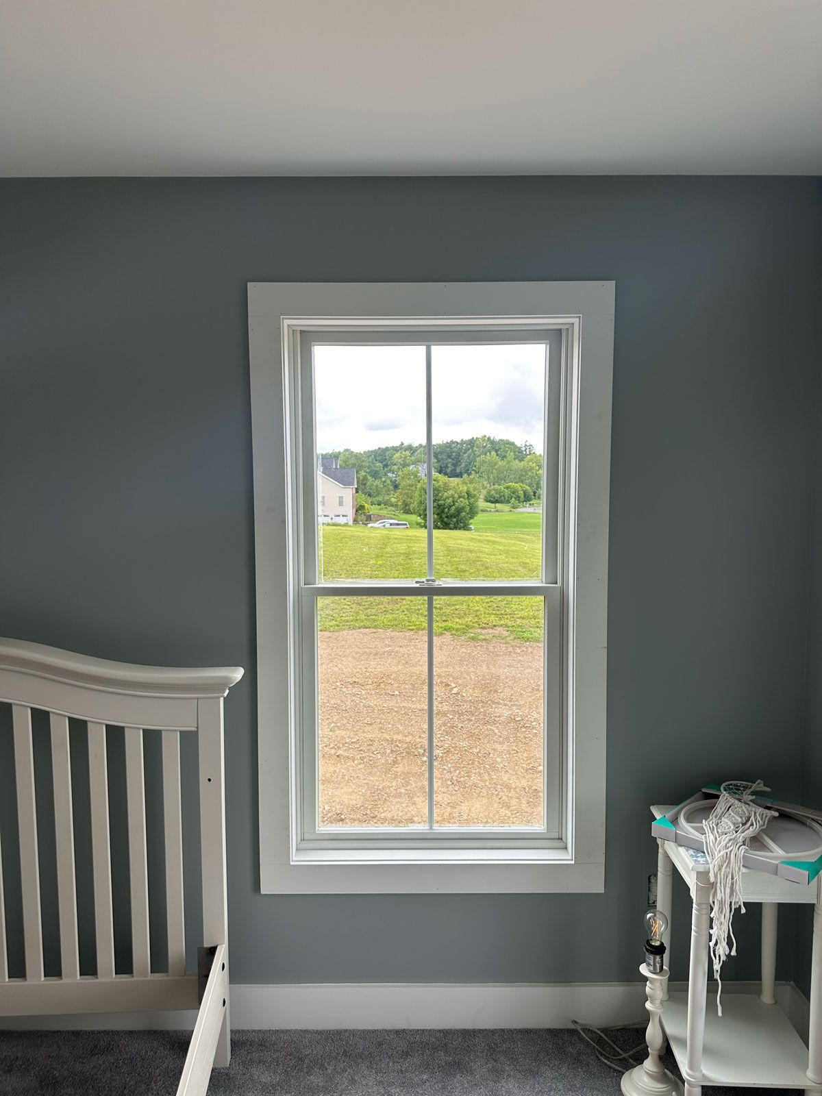 A bedroom with a bed and a window with a view of a field.