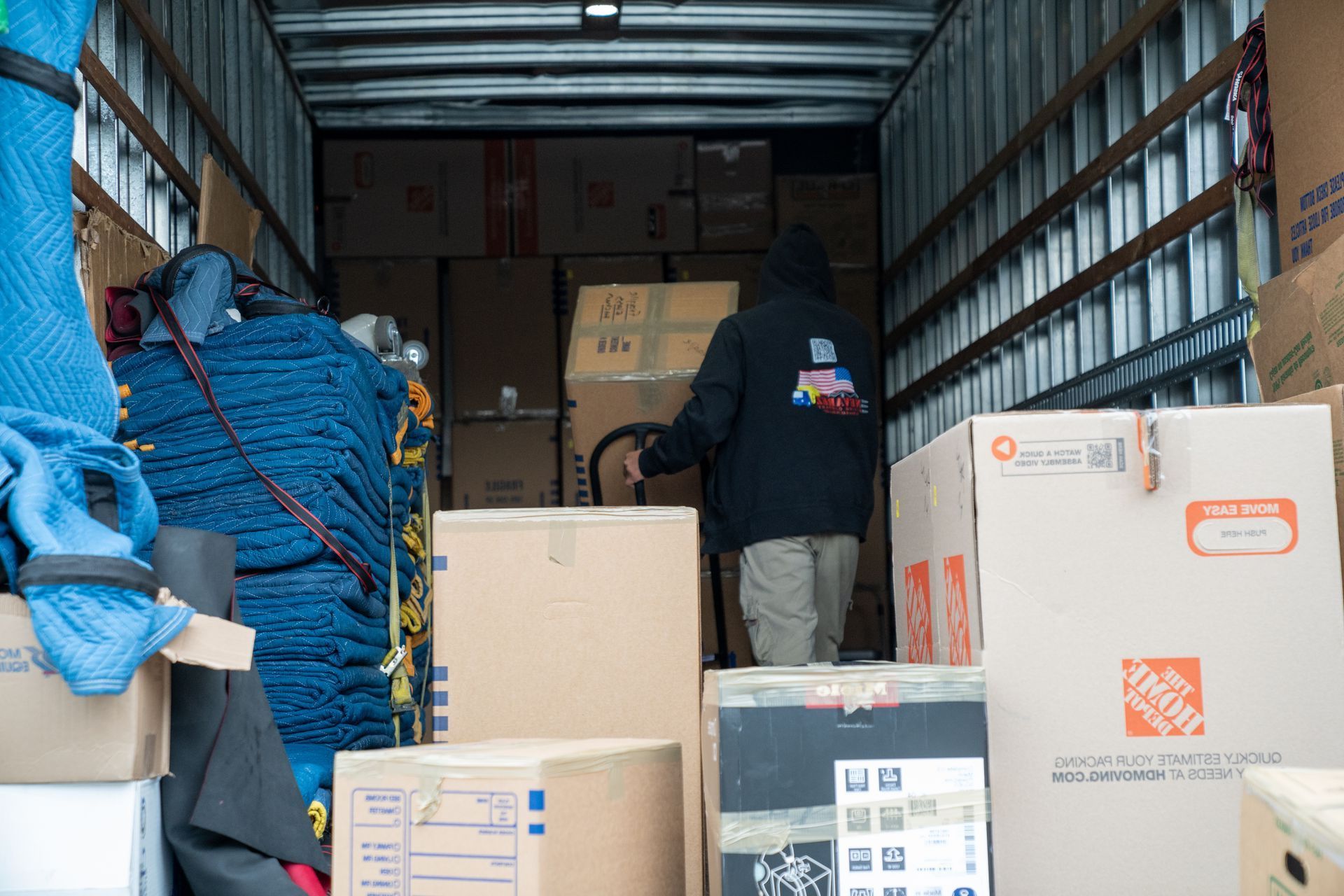 A man is loading boxes into a moving truck.