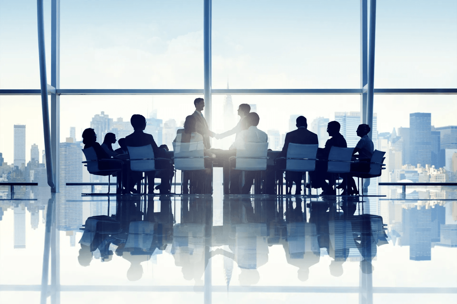 A group of people are sitting around a table in a conference room.