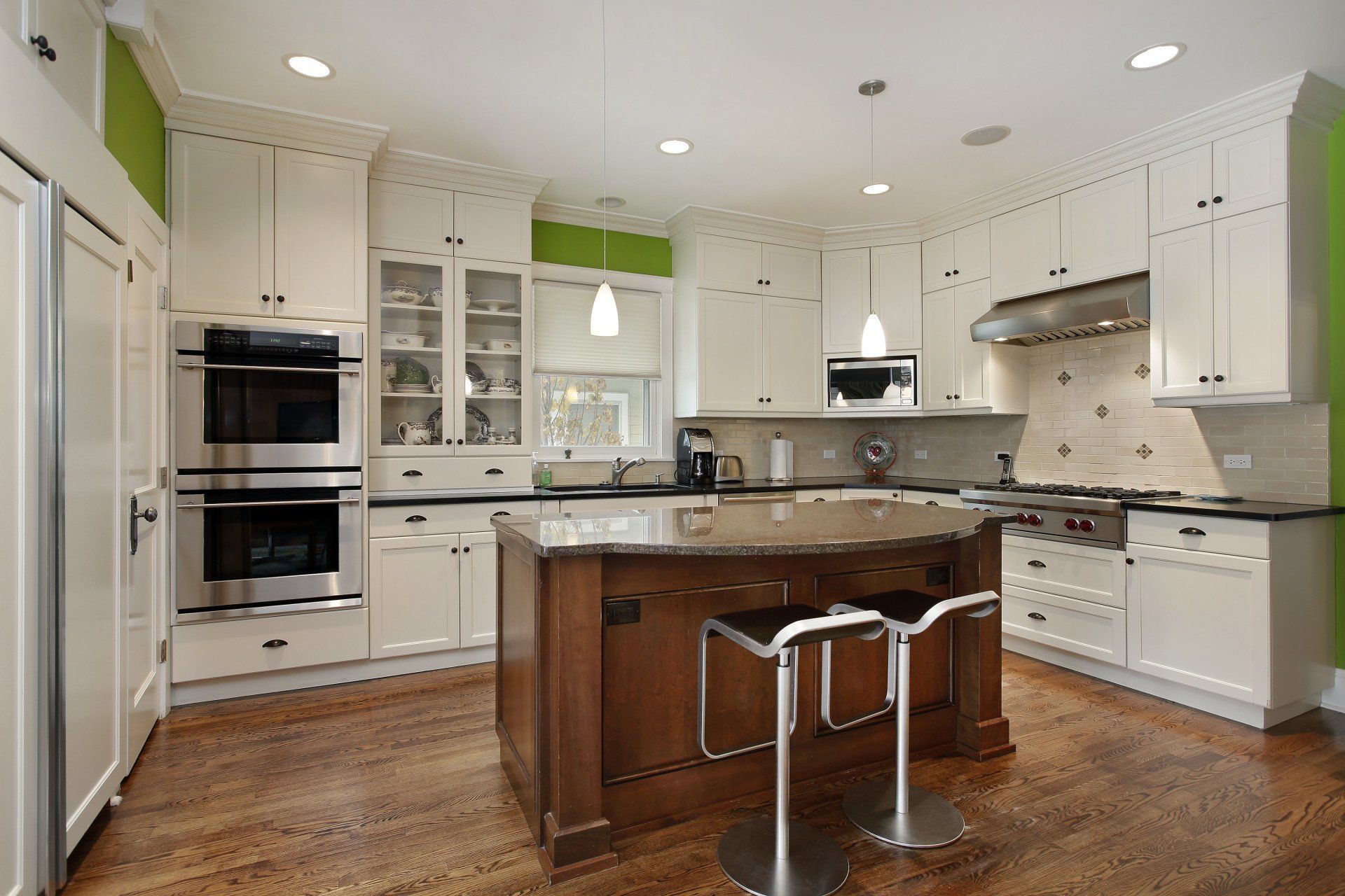 A kitchen with white cabinets and stainless steel appliances