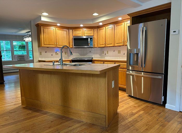 A kitchen with stainless steel appliances and wooden cabinets.
