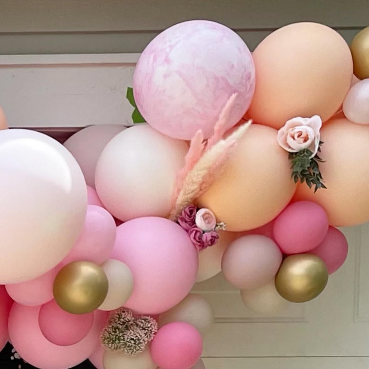 A bunch of pink and orange balloons with flowers on them.
