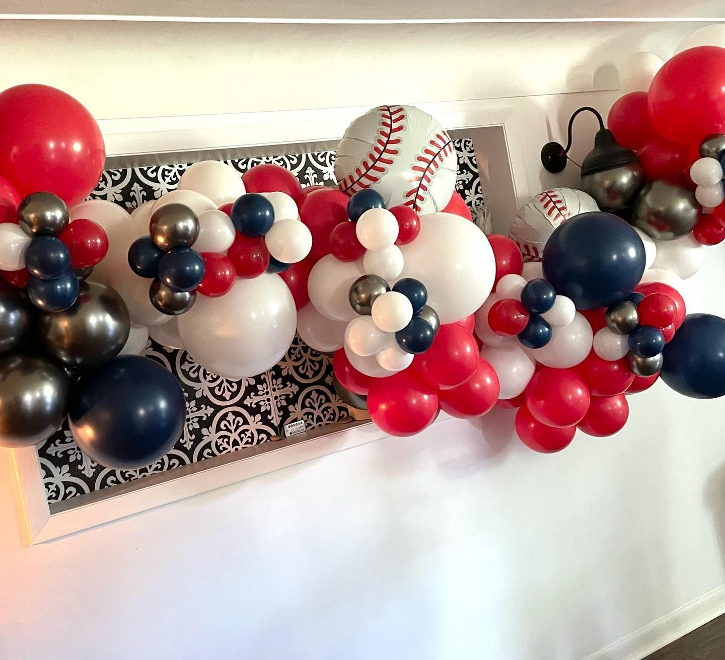 A bunch of red, white, and blue balloons on a wall.