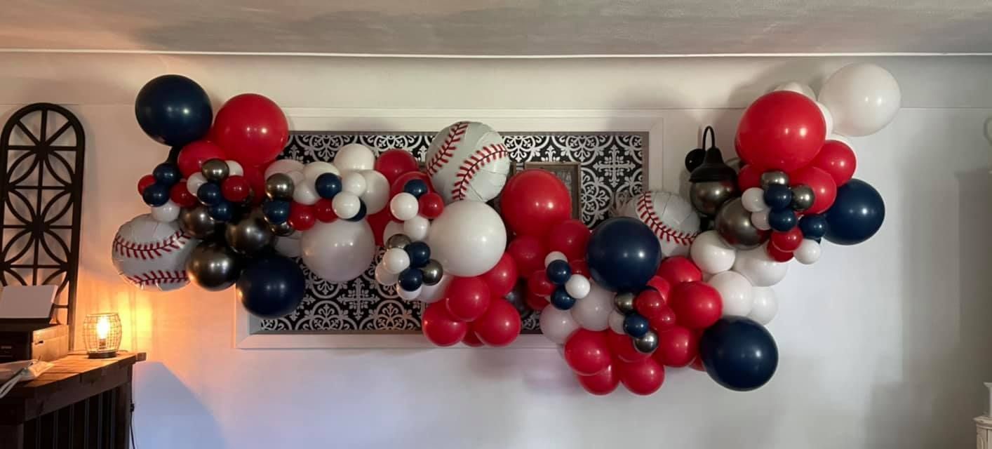 A bunch of red, white, and blue balloons are hanging on a wall.