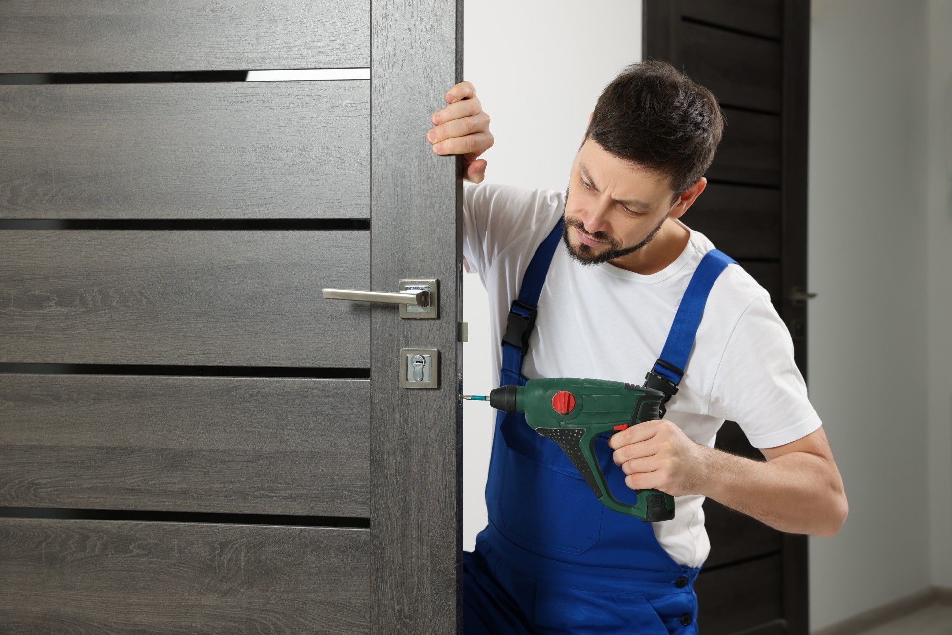 A man is installing a door with a drill.