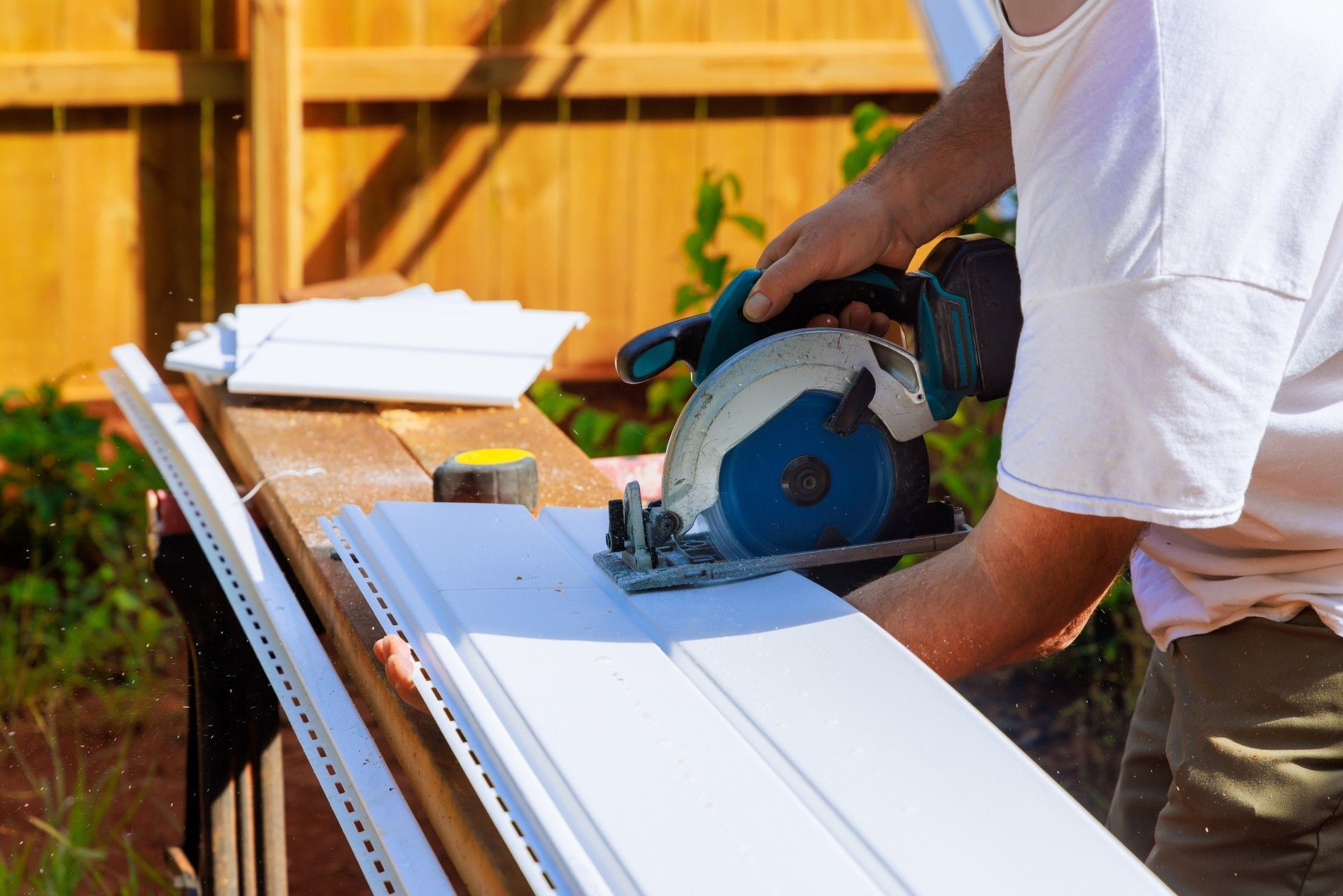 A man is using a circular saw to cut a piece of wood.