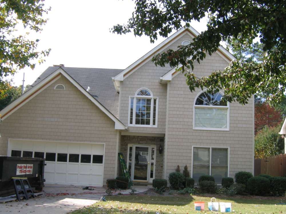 A large beige house with a white garage door