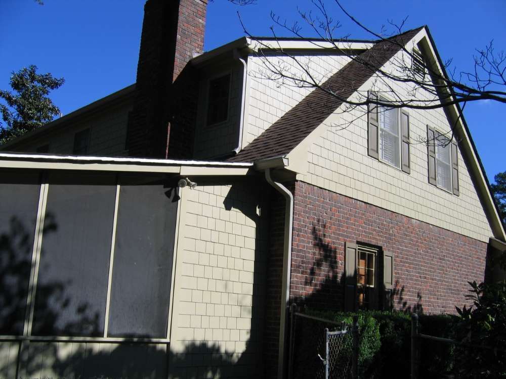 A house with a screened in porch and a chimney