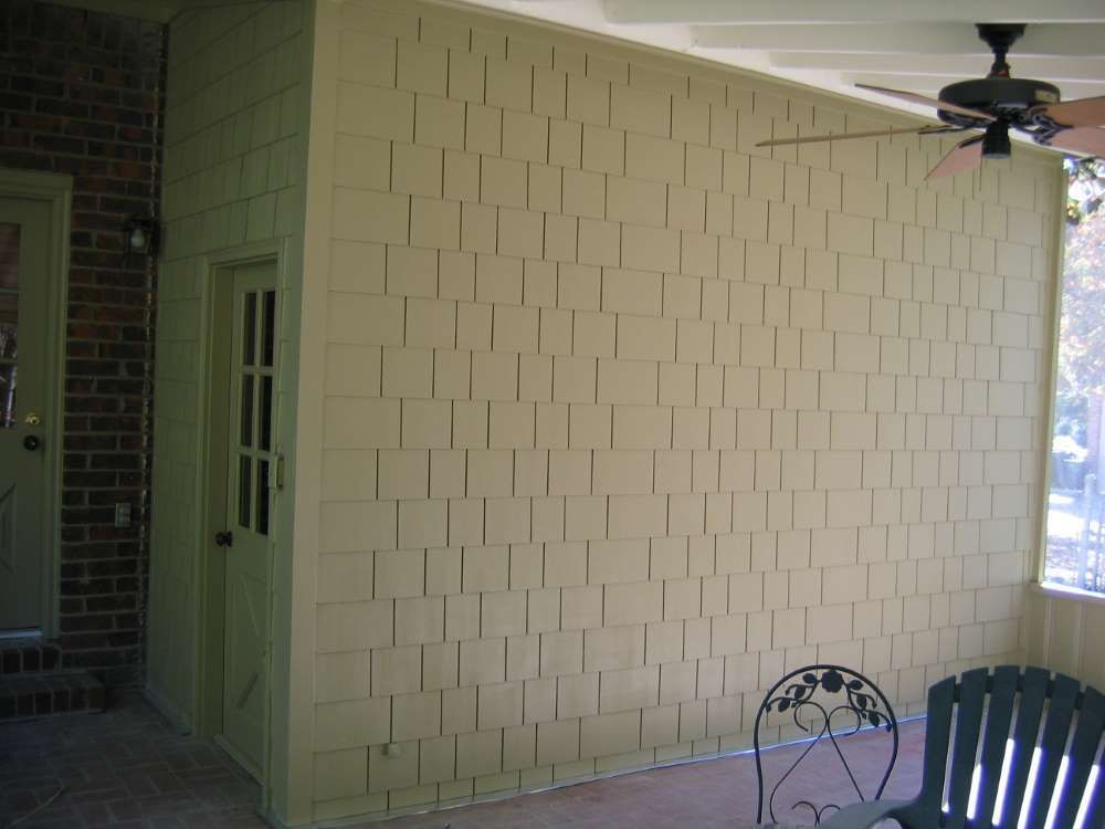 A porch with a chair and a ceiling fan