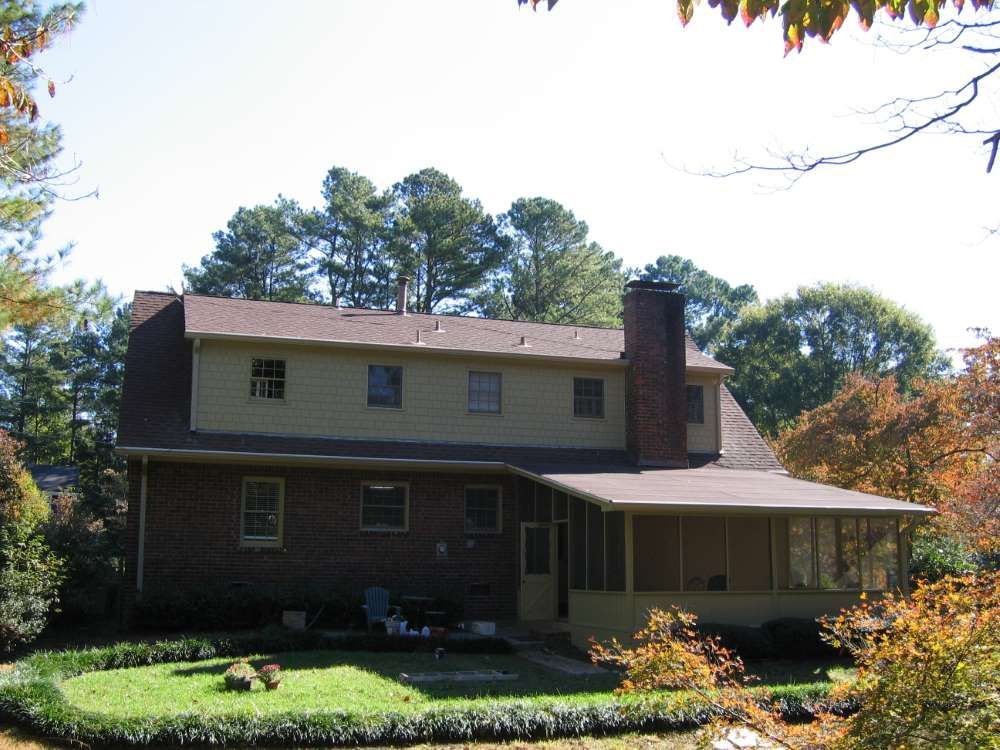 A brick house with a porch and a chimney