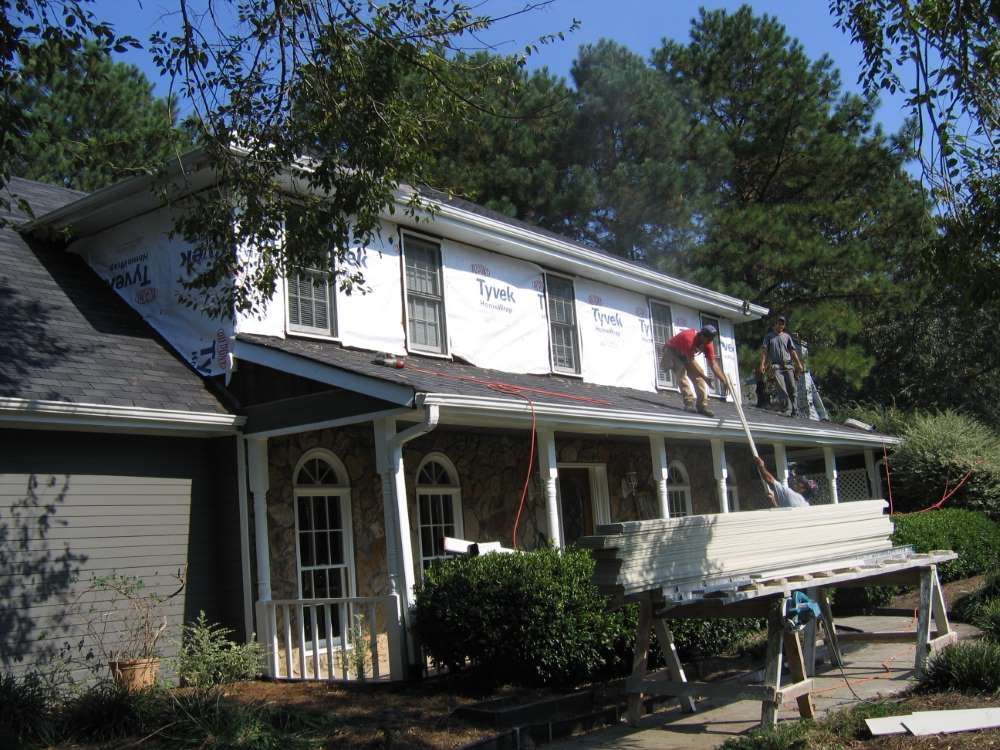 A group of men are working on the roof of a house