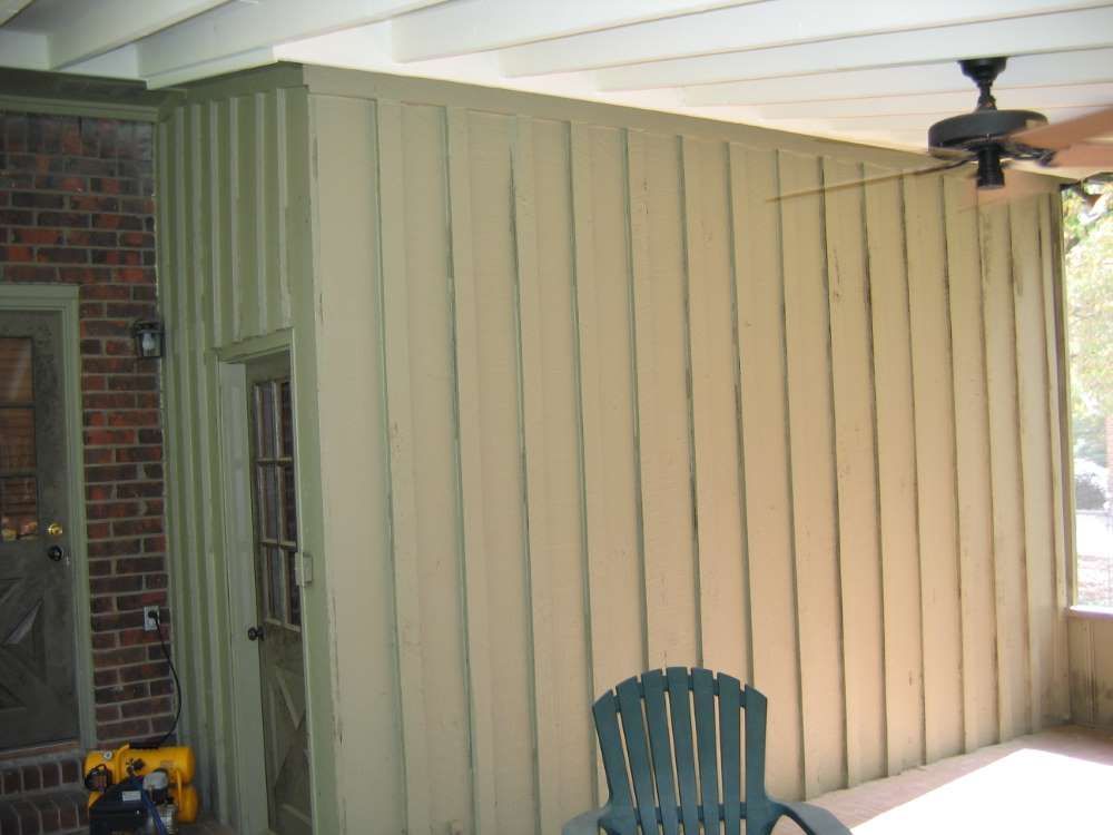 A porch with a chair and a ceiling fan