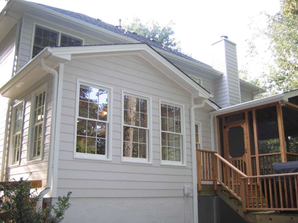 A white house with a screened in porch and stairs