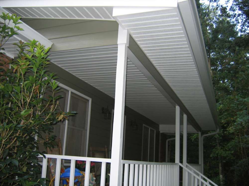 A porch with a white railing and a white roof
