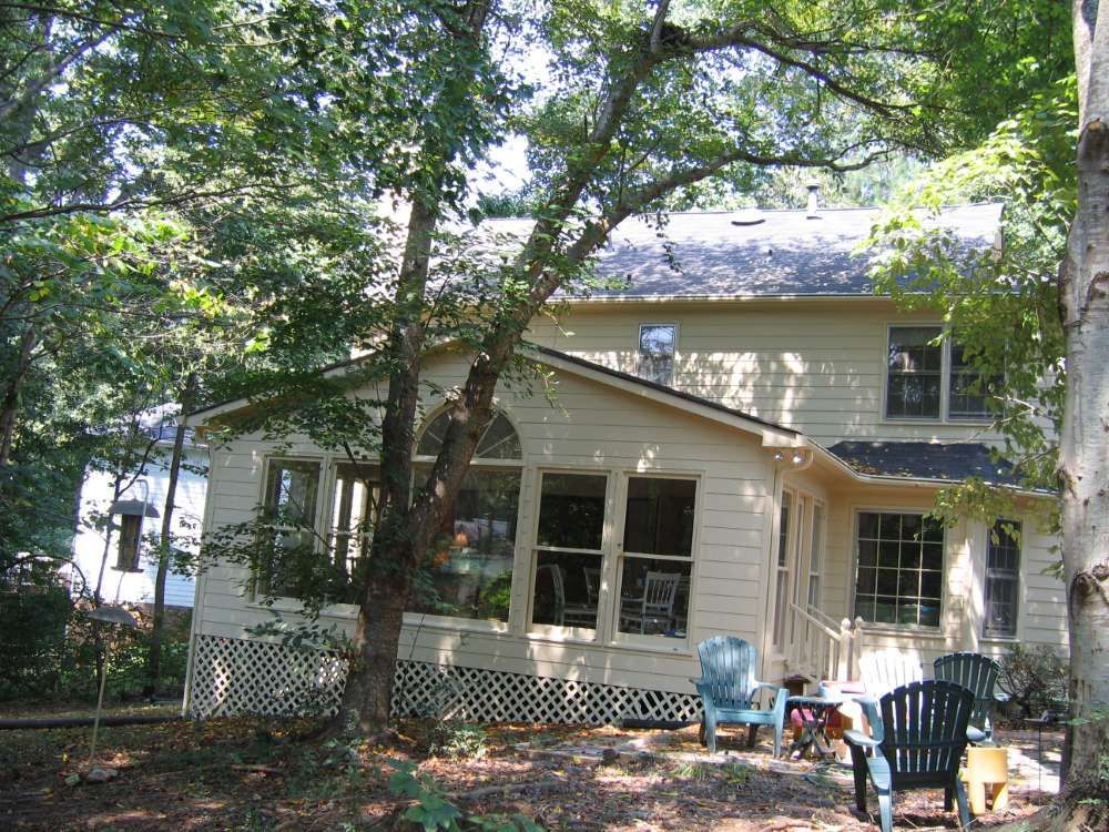 A house with a porch and chairs in front of it