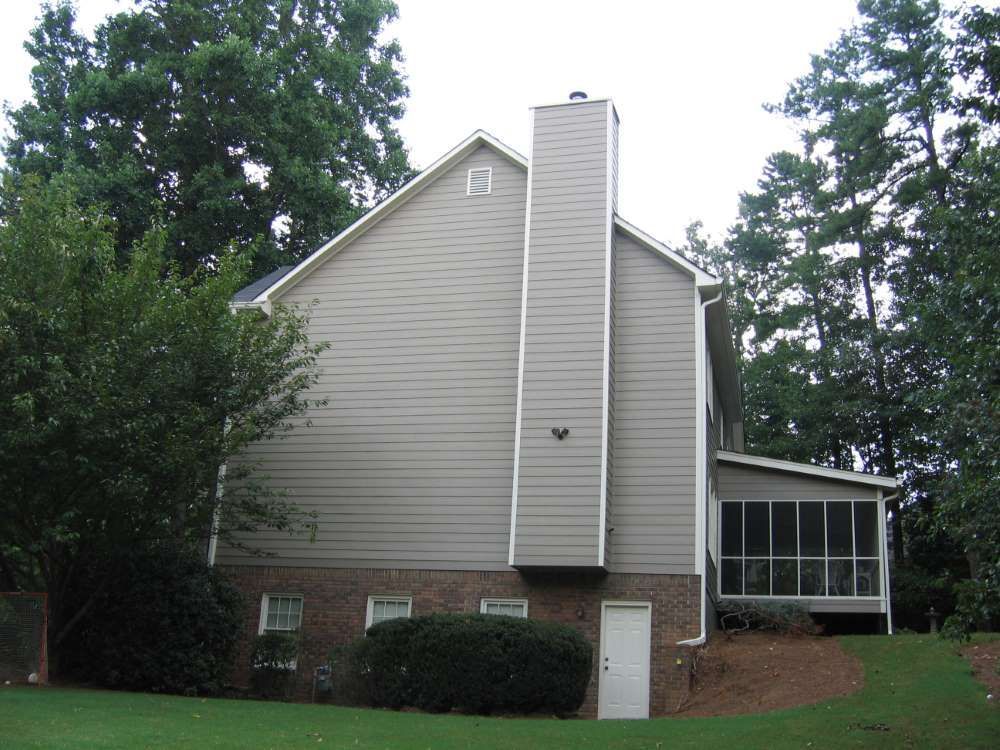 A house with a screened in porch and a chimney