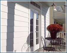 A porch with a table and chairs and a vase of flowers