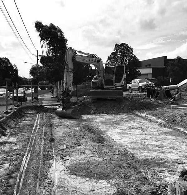 A black and white photo of a construction site with a Hyundai excavator