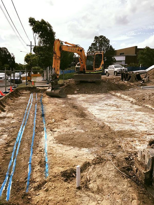 A yellow excavator is working on a construction site