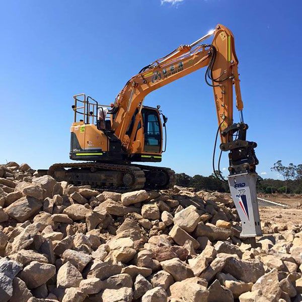A large excavator with a rock breaker attachment