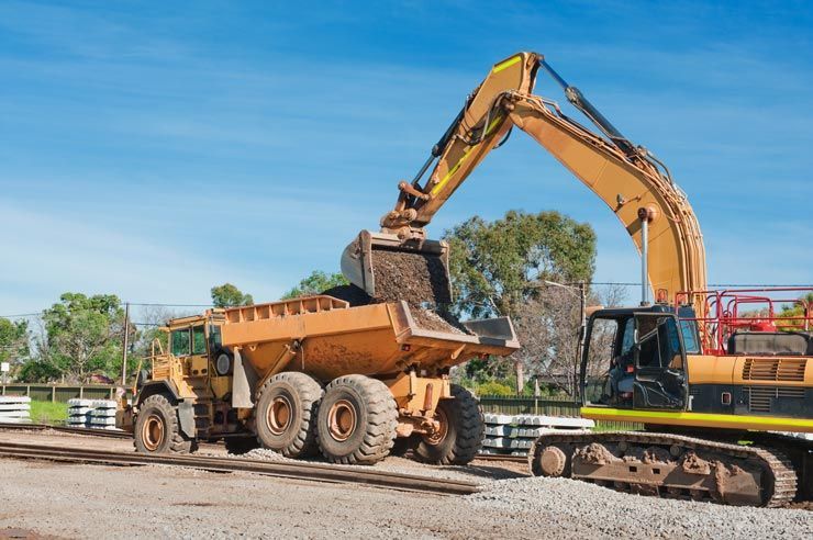 An excavator loading a dump truck