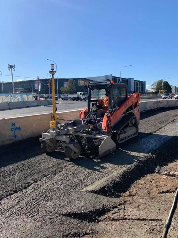 Kubota skid steer laying asphalt