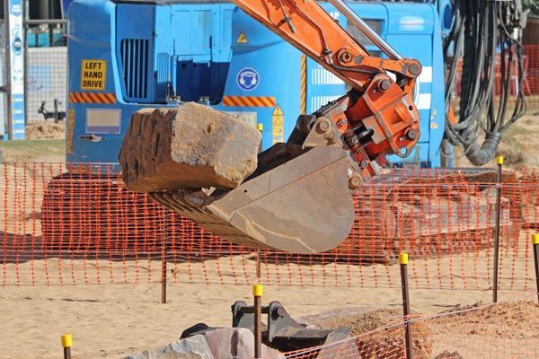An excavator moving a large rock
