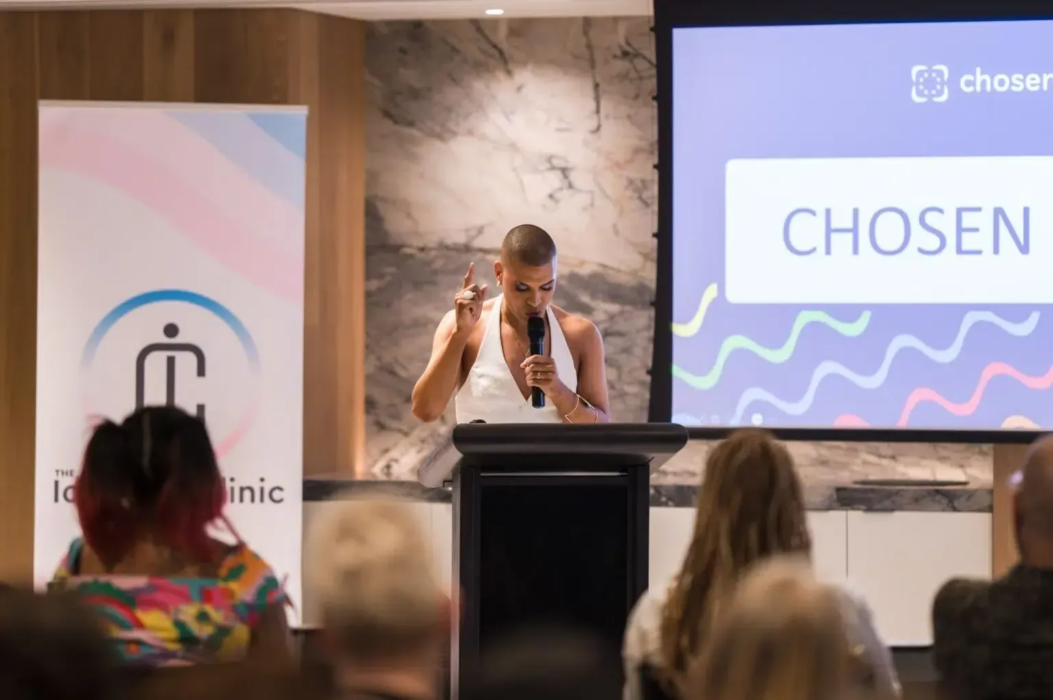 Person speaking at a podium with a logo for the
